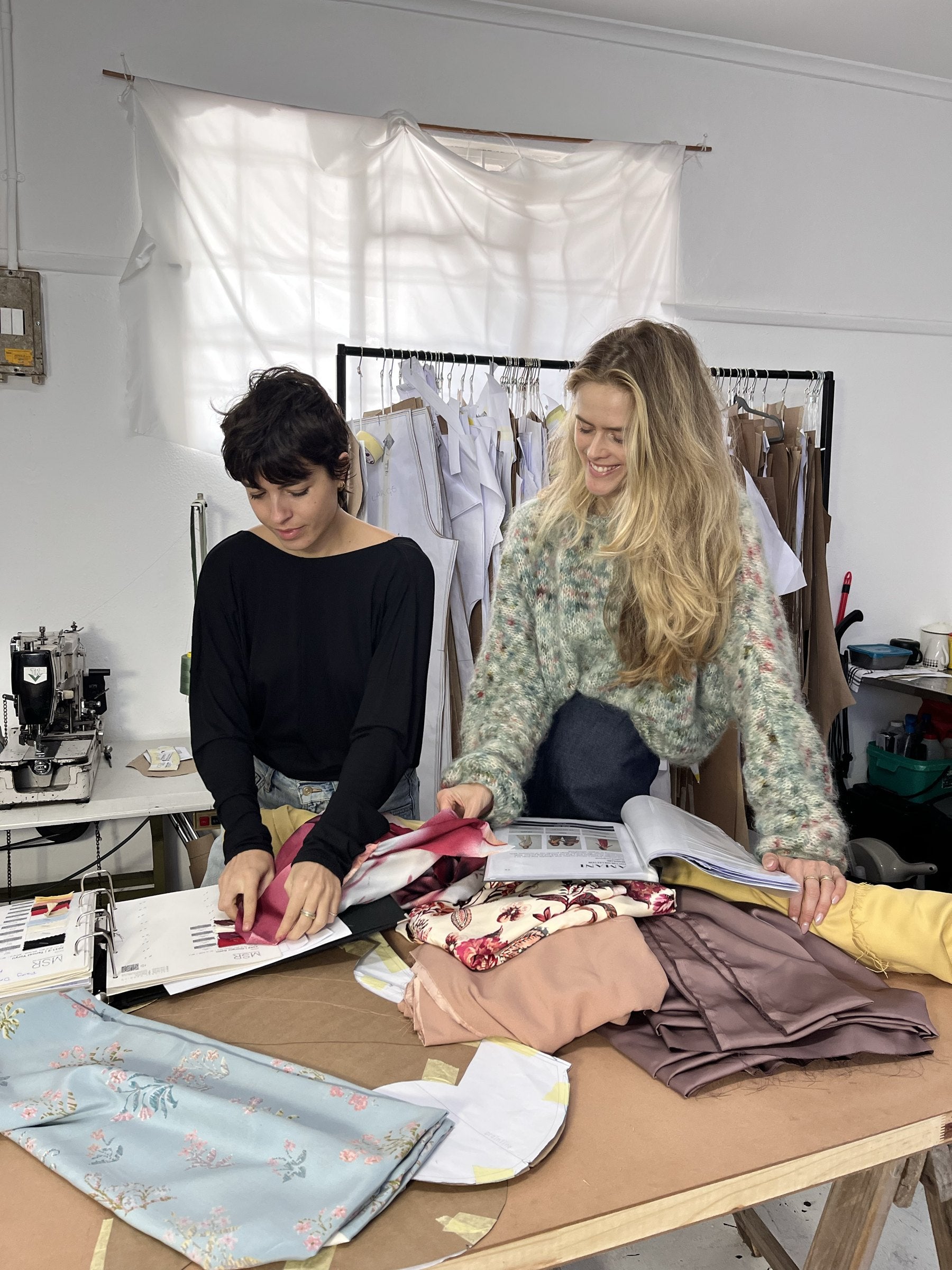 Cam and Dana choosing fabrics at the cutting table in the Amani studio in Cape Town
