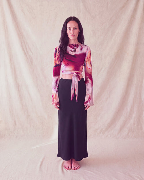 Bloom Top in rose print with bell sleeves and a front tie, worn with a black maxi skirt