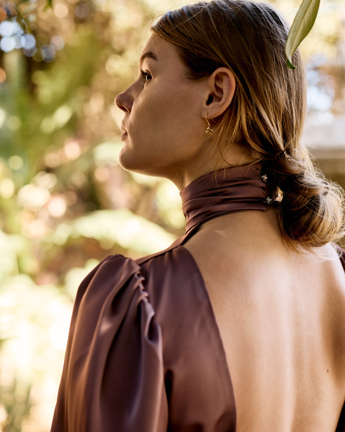 Open back and neck tie of the Tariro Dress in bordeaux pink satin